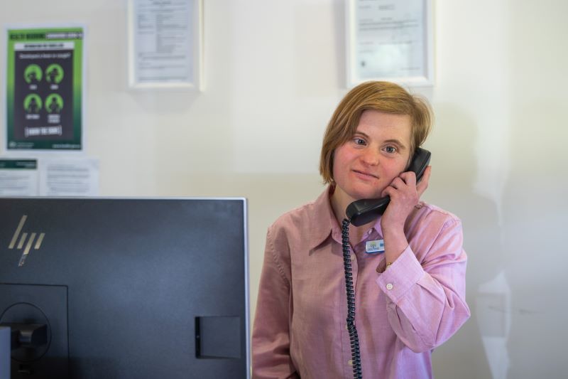 lady with disability holding phone at work